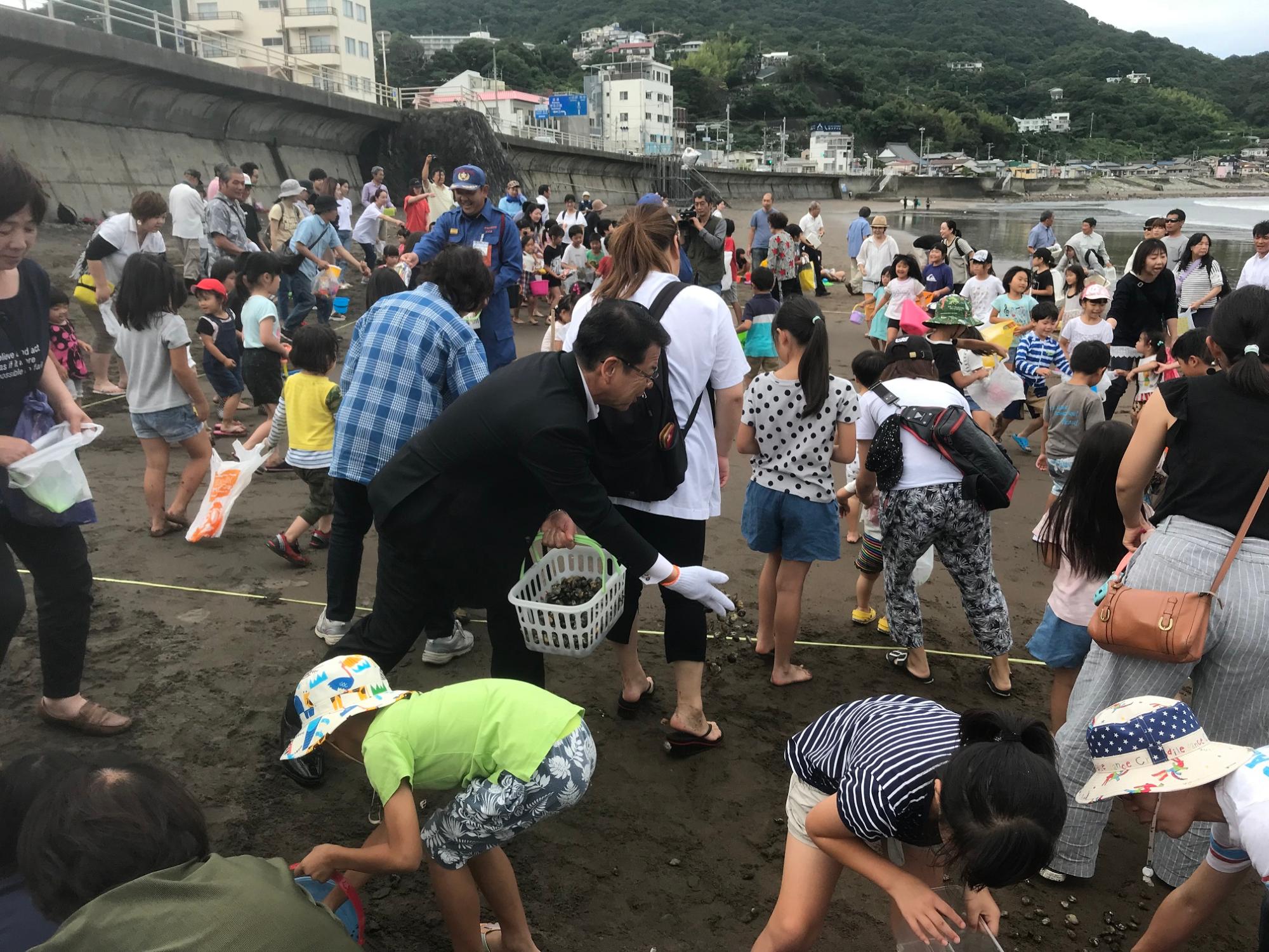 あさりまきを行う小野市長