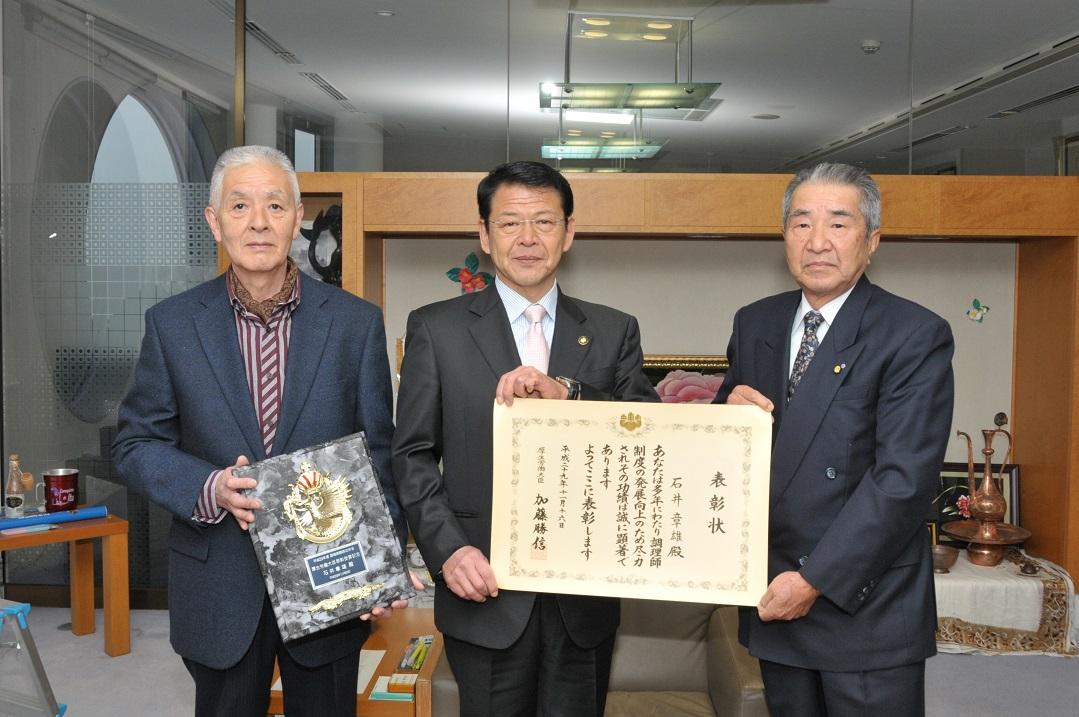 2017年11月22日石井章雄さんの表彰状を掲げる市長の写真