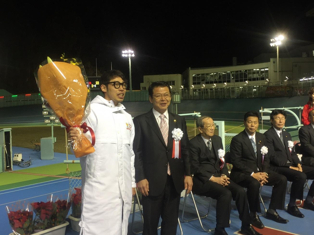 2017年12月10日花束を右手で持った早坂秀悟選手と横に並ぶ市長の写真