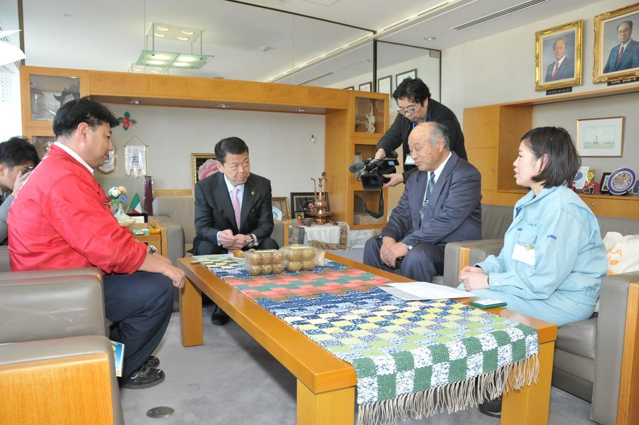 JAあいら伊豆のいで湯っこ市場の皆さんがキウイフルーツ「東京ゴールド」を伊東市長に紹介する様子の写真