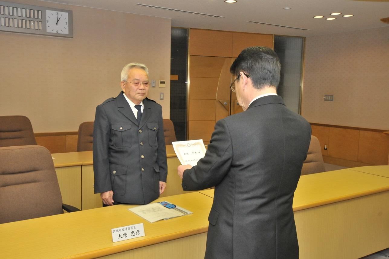 新たに交通指導員を委嘱された大柴忠彦さんへ委嘱状を渡す伊東市長の写真