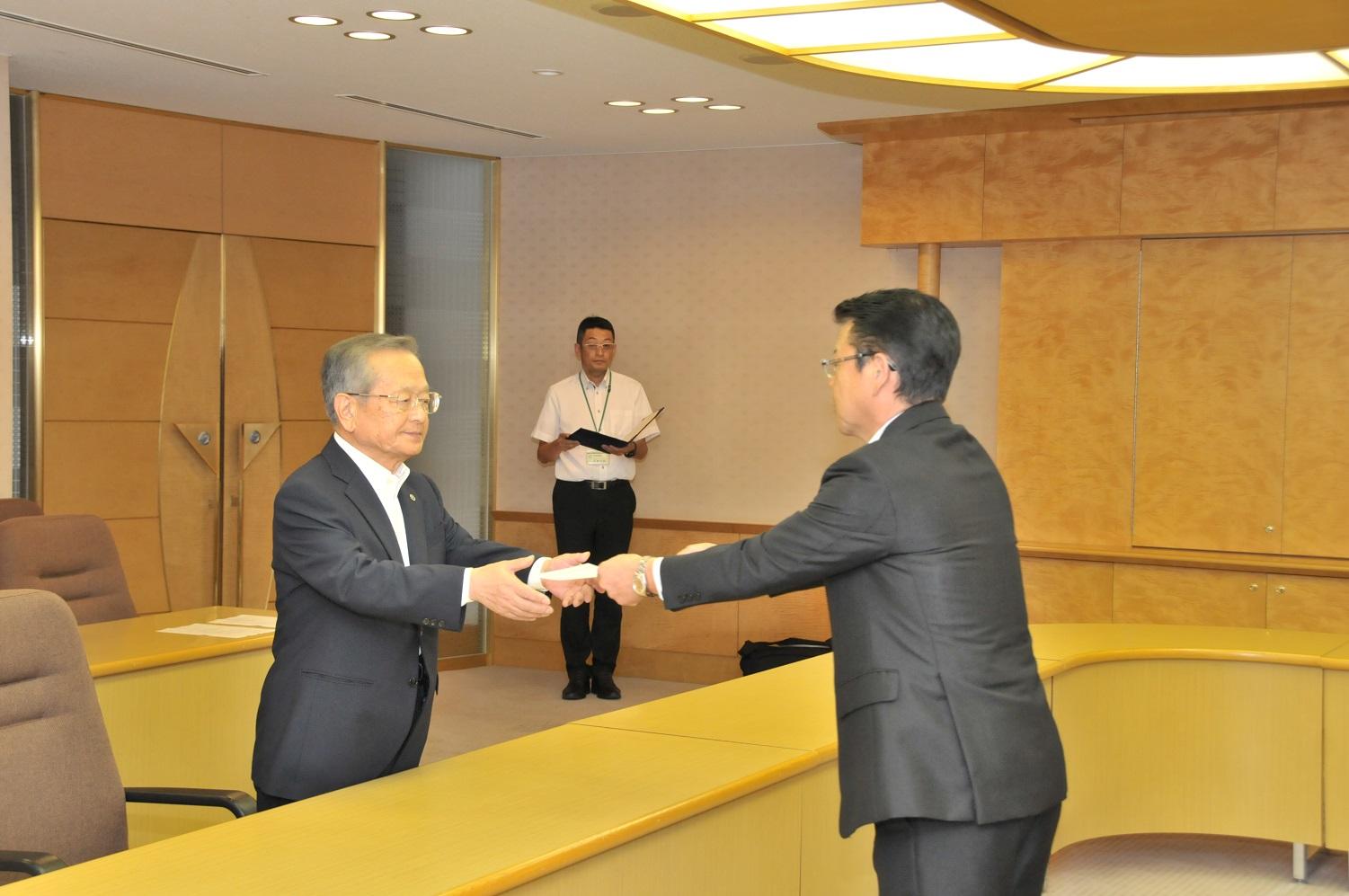 固定資産評価審査委員会委員の新任委員である松屋永久さんと伊東市長の写真