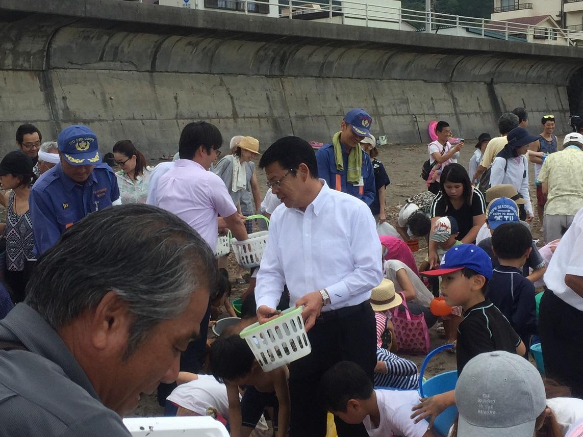 宇佐美海水浴場海開き海上安全祈願祭での「アサリまき」をする伊東市長の写真