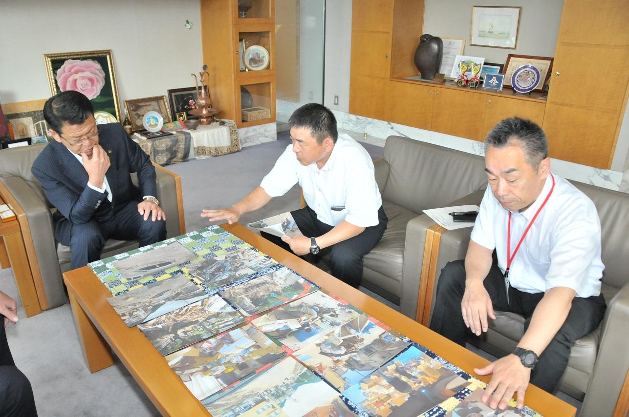 危機対策課の和田弘貴防災専門官から現地の被害状況や活動内容の報告を受ける伊東市長の写真