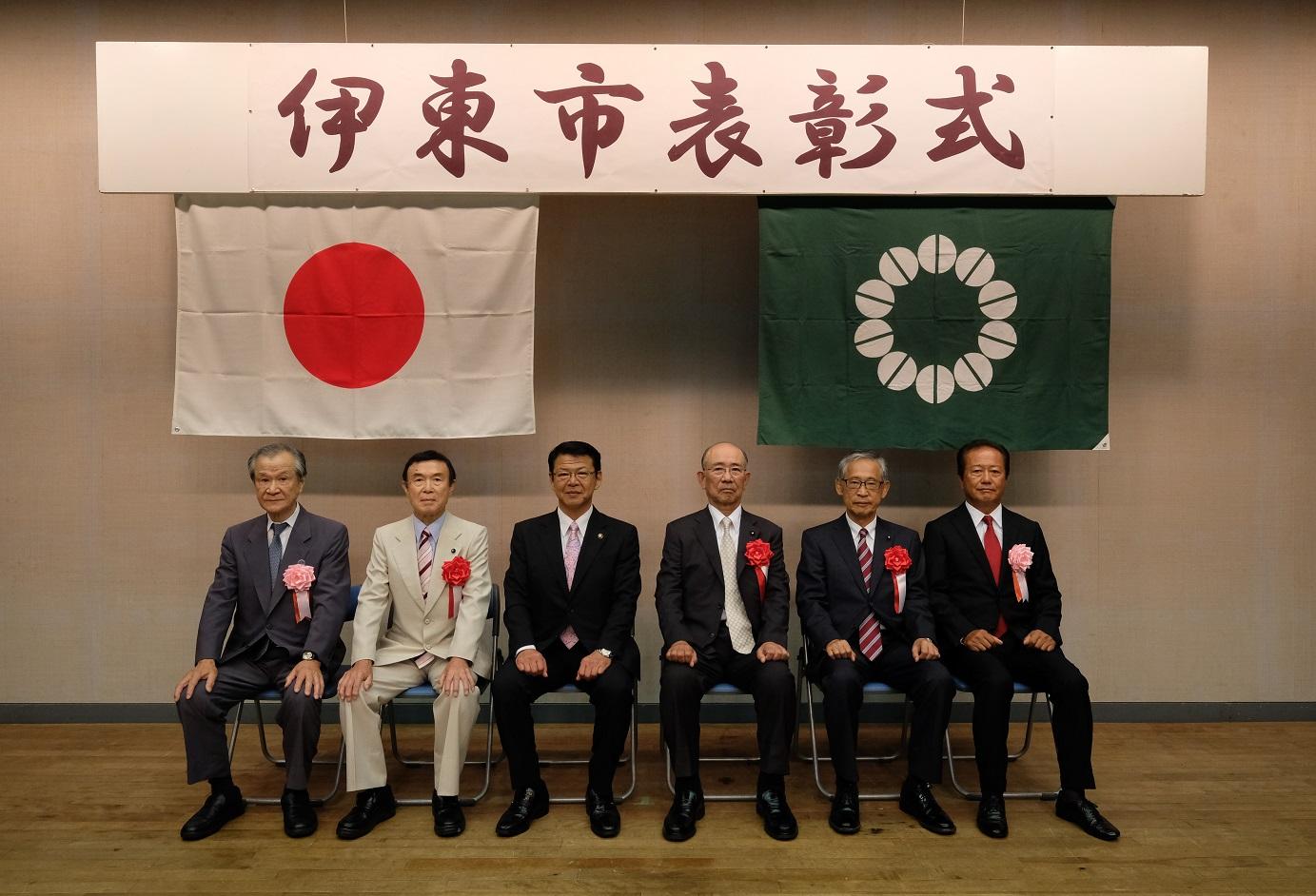 2018年8月10日 表彰された7人と共に着席する市長の写真