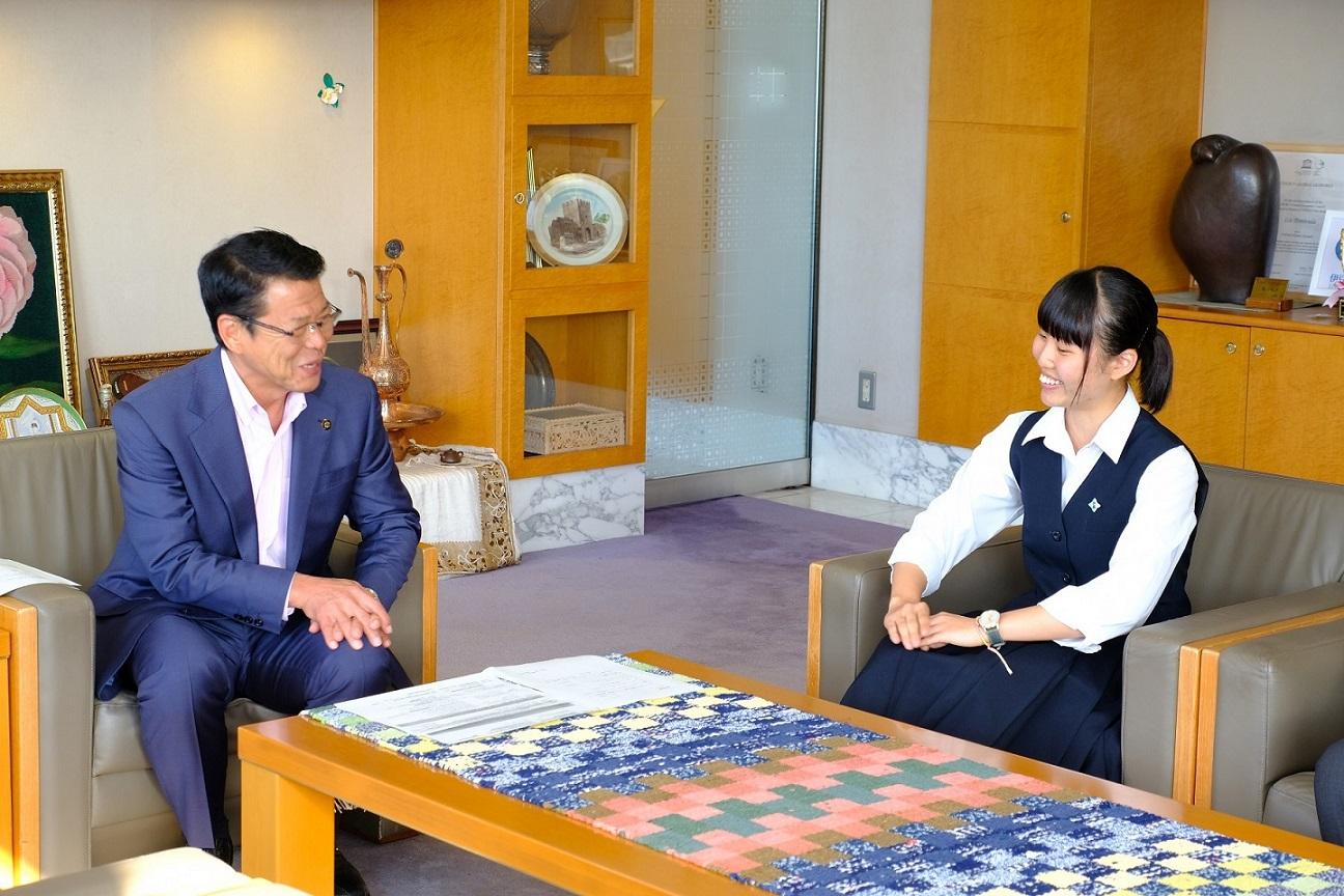2018年9月3日 市長公室の椅子に座り帰国の報告をする里吉凛香さんと市長の写真