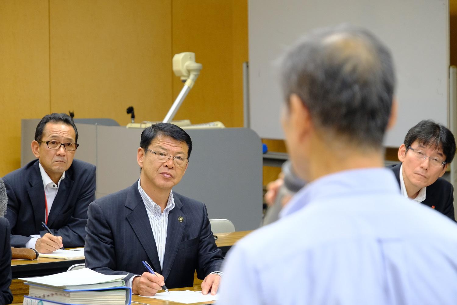 玖須美地区で実施されたタウンミーティングでメモを取る伊東市長の写真