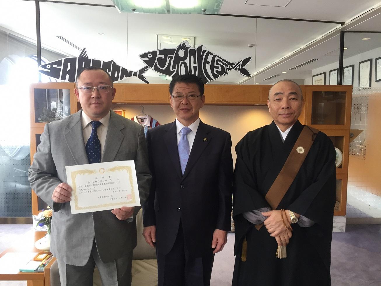2019年1月25日受領書を掲げる川奈蓮慶寺の2人と並ぶ市長の写真