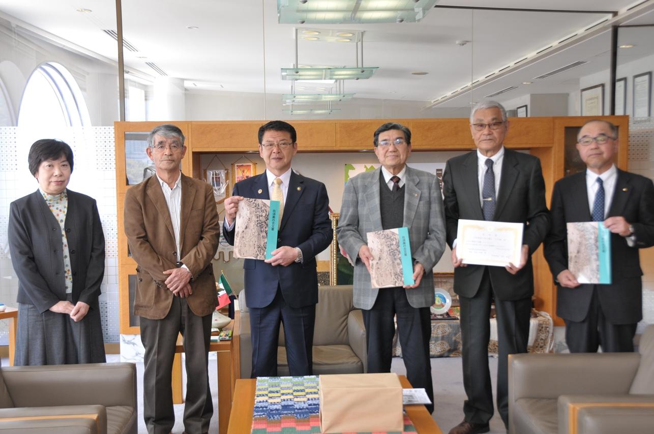 「玖須美の古文書」を寄贈した玖須美財産区の皆さんと伊東市市長の写真