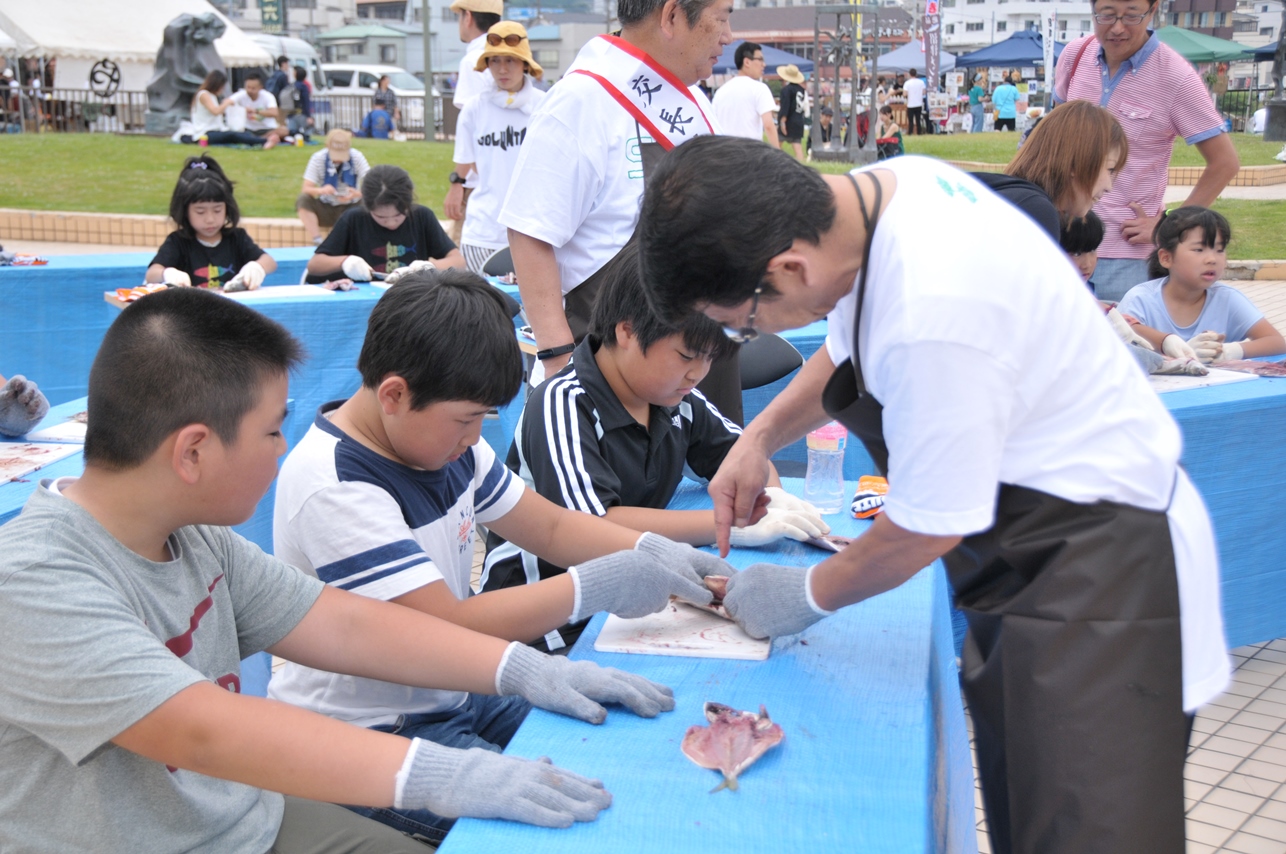 子どもたちにアジの開き方を教える小野市長