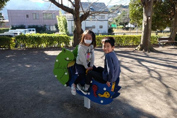 2人乗りムービング遊具に座る女の子と男の子の写真