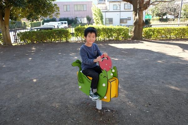1人乗りムービング遊具に座る男の子の写真