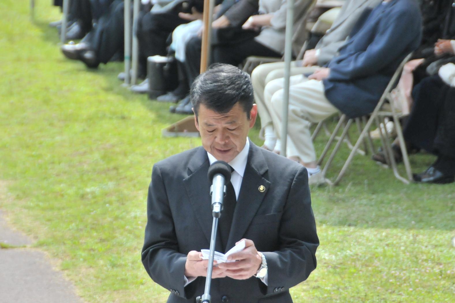 2017年5月29日マイクスタンドに立ちメモを読む市長の写真