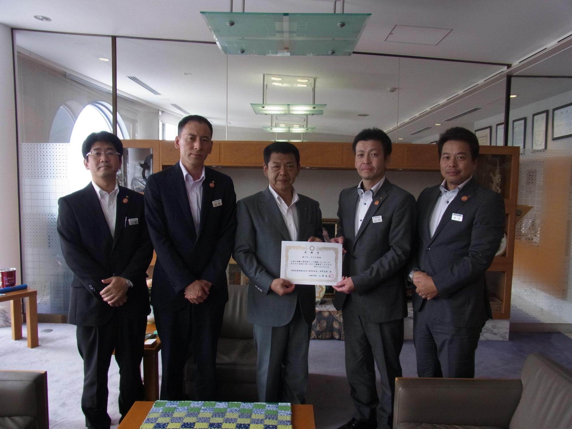 2017年6月22日東海自動車株式会社の4人と横に並び受領証を掲げる市長の写真