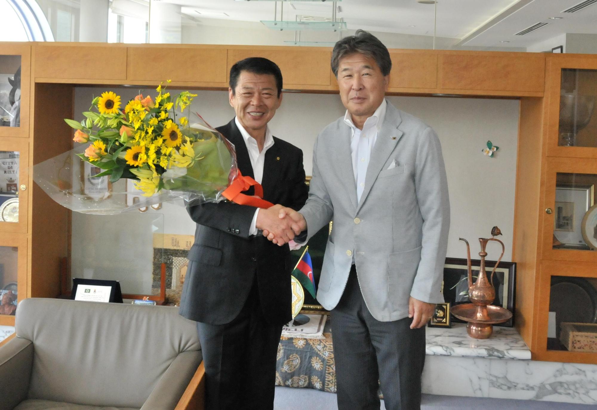 2017年7月5日花束を持ち竹山専務理事と握手をする市長の写真