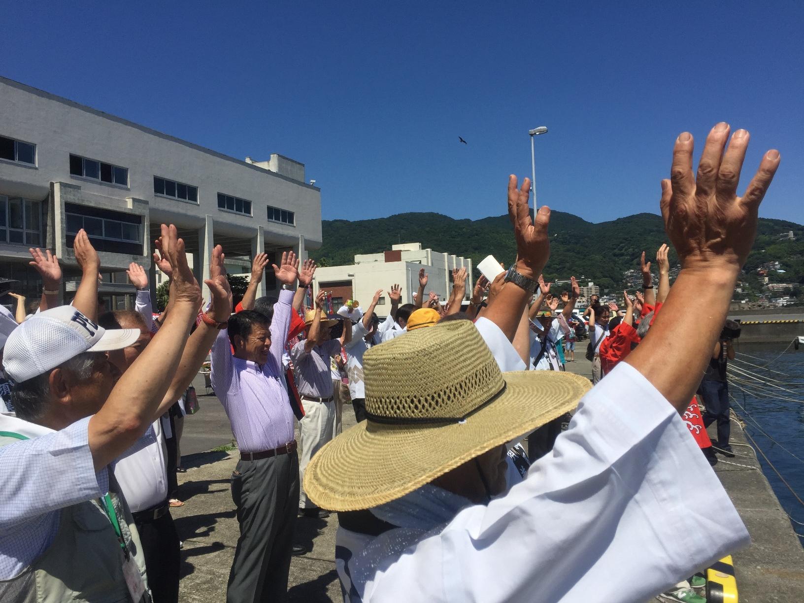 2017年7月15日港で両手を挙げる人たちと市長の写真