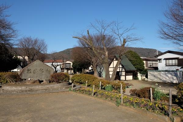完成記念碑と花壇とケヤキ・桜の木の写真