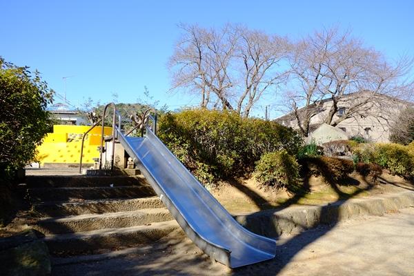 公園上段へ登る階段と階段に設置された滑り台の写真