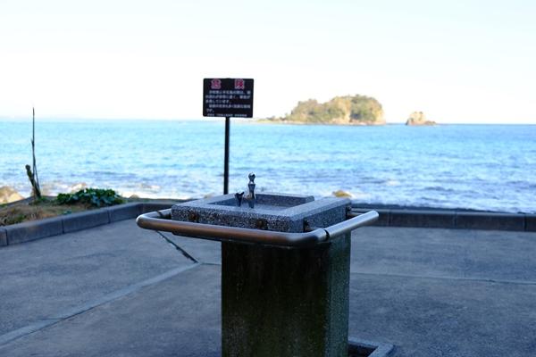 水飲み・手洗い場と海を挟んだ手石島の写真