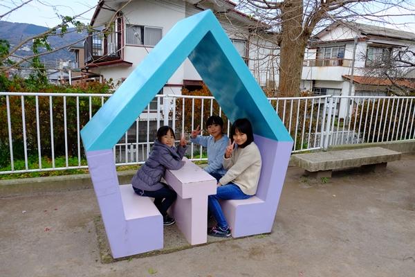 東屋に座りピースをする女の子3人の写真