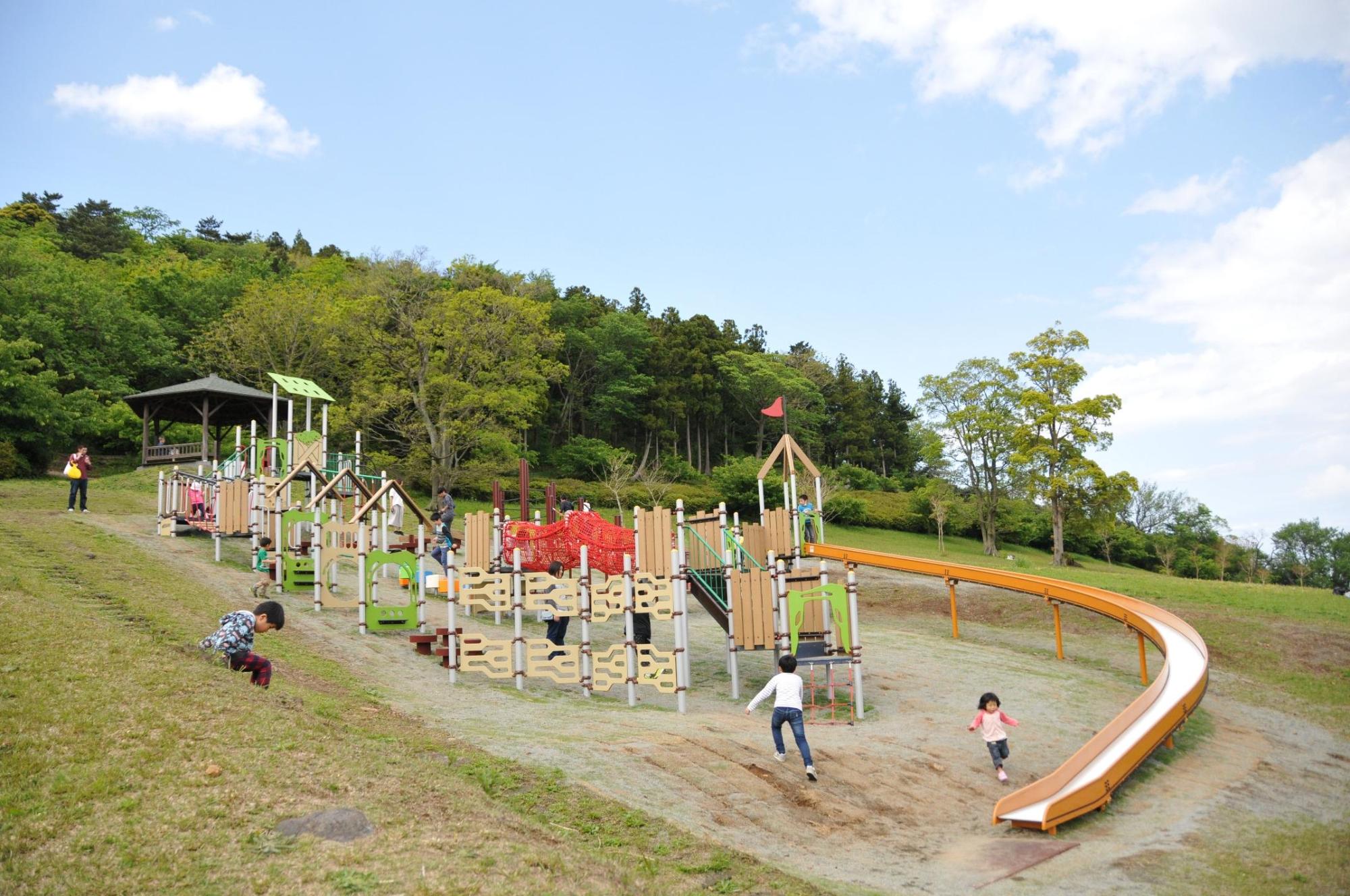 公園の遊具と公園で遊ぶ子供たちの写真