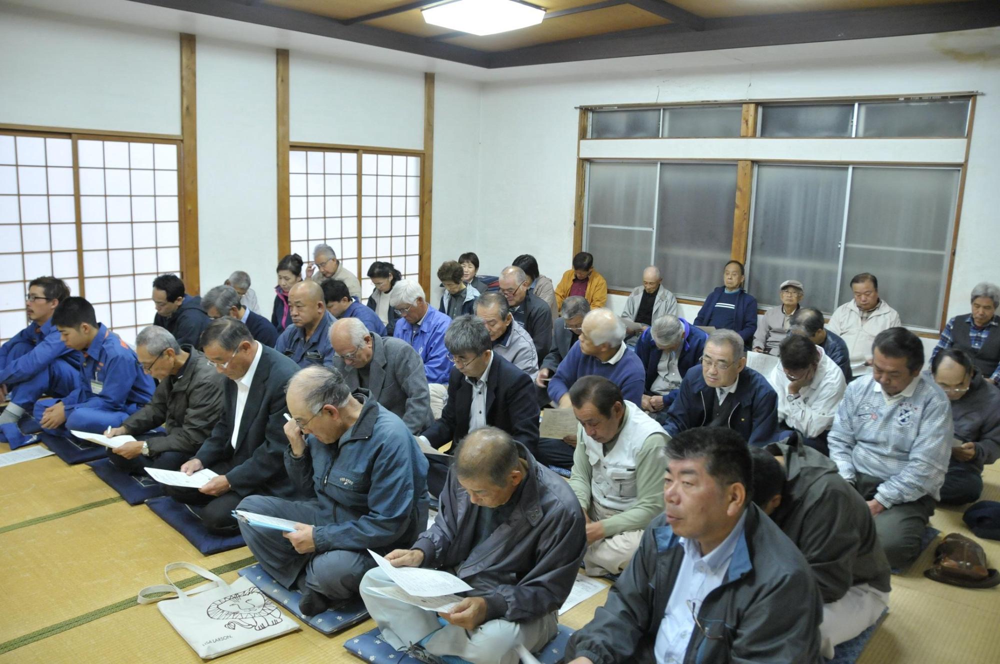 十足区民会館の畳に座る地域タウンミーティング出席者らの写真