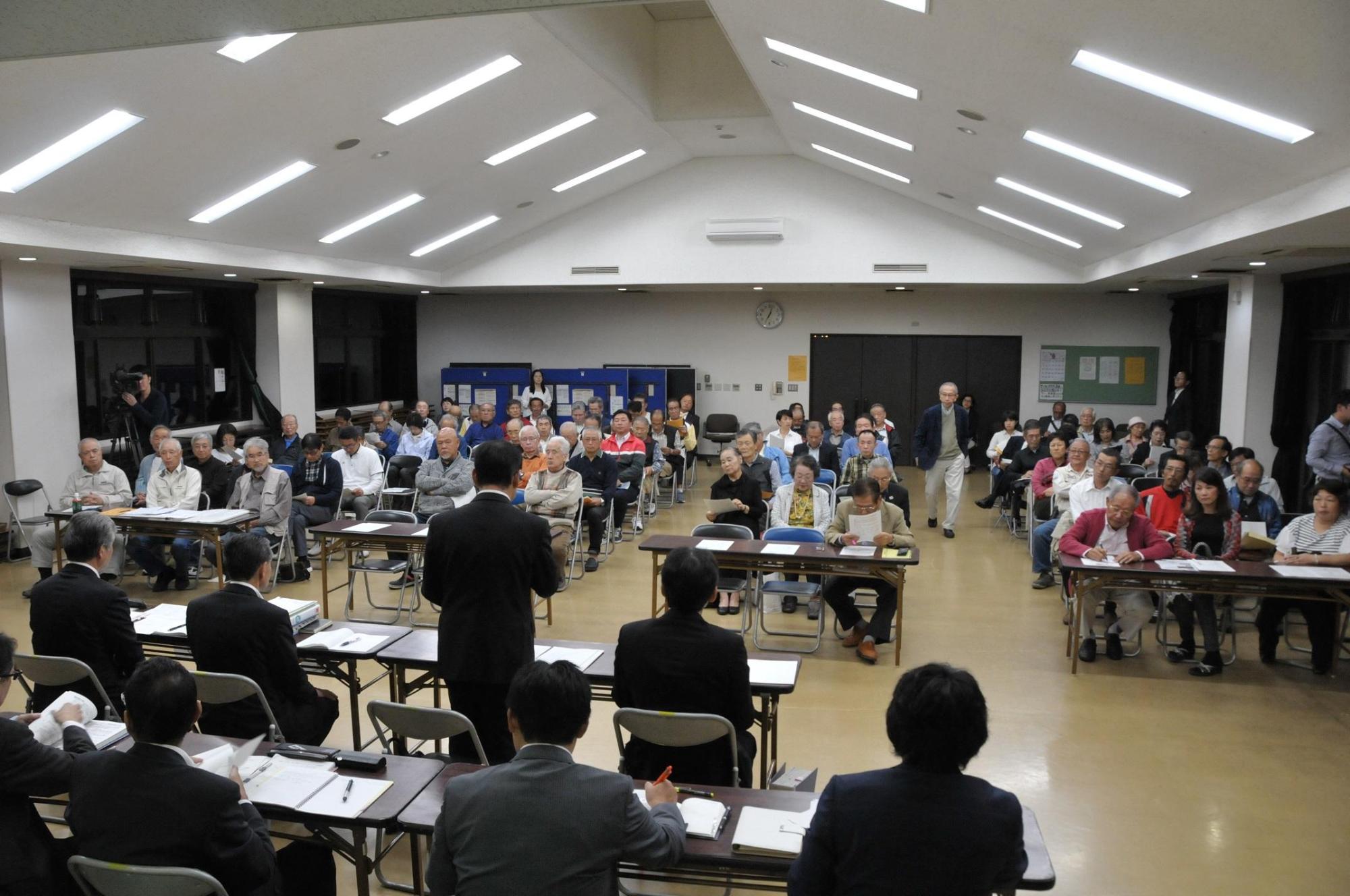 八幡野の会場席に着き地域タウンミーティングをする出席者らの写真