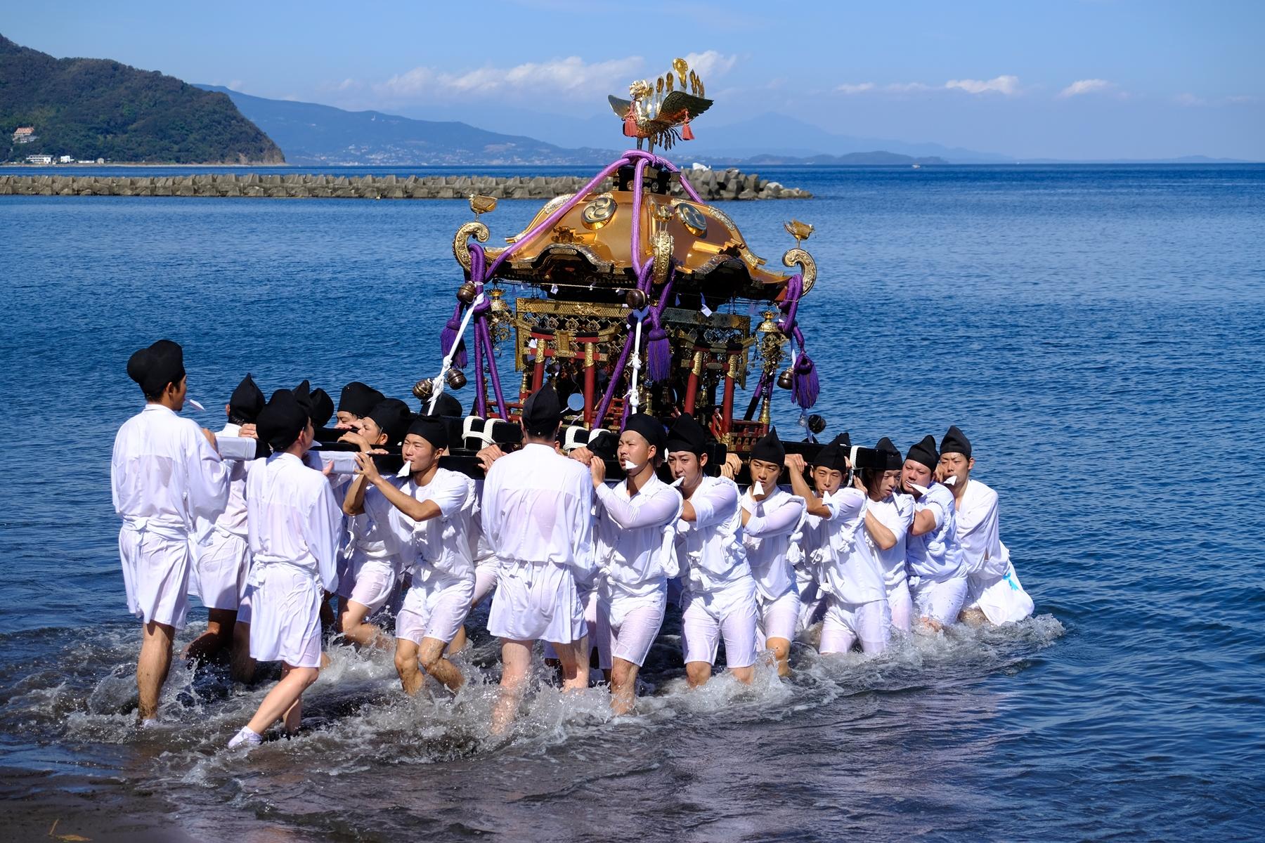 沖合から担つがれて上がる神輿の写真