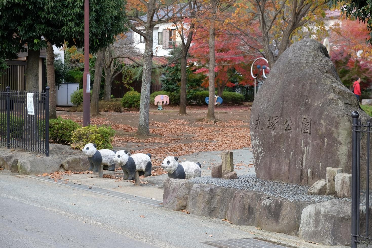入口に大きな岩と、パンダの車止めが3つ並んでいる丸塚公園の入口の写真